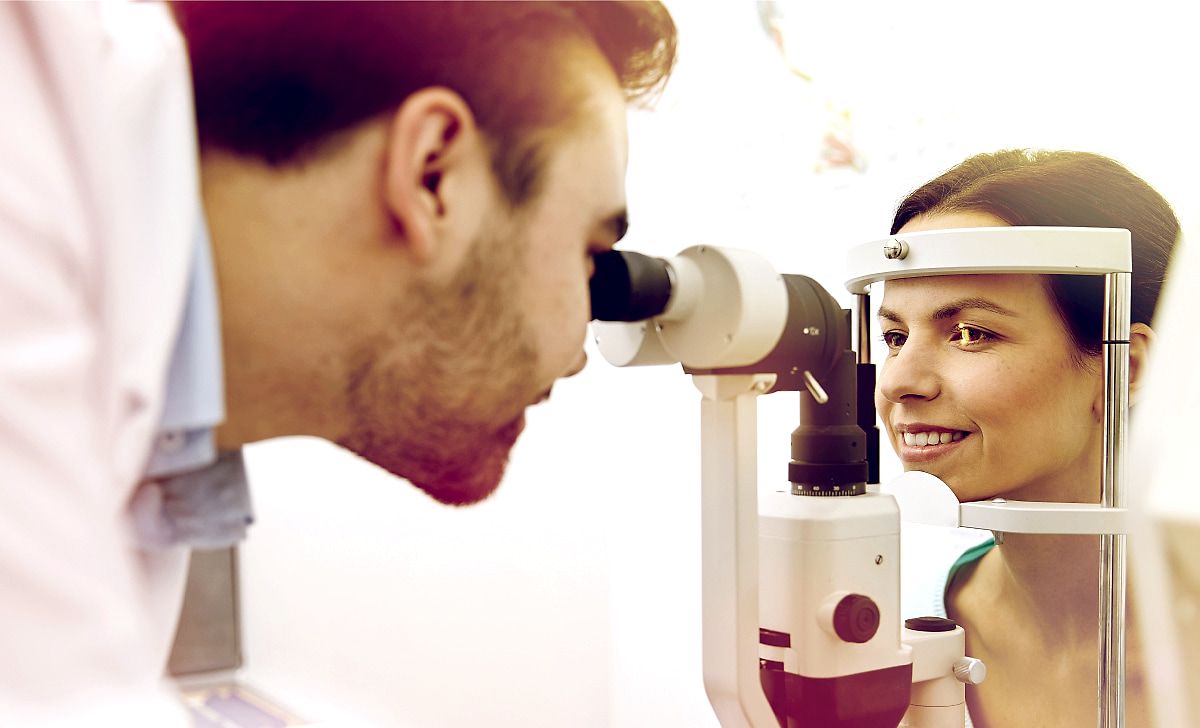 Optómetra examinando los ojos de una paciente con una lámpara de hendidura